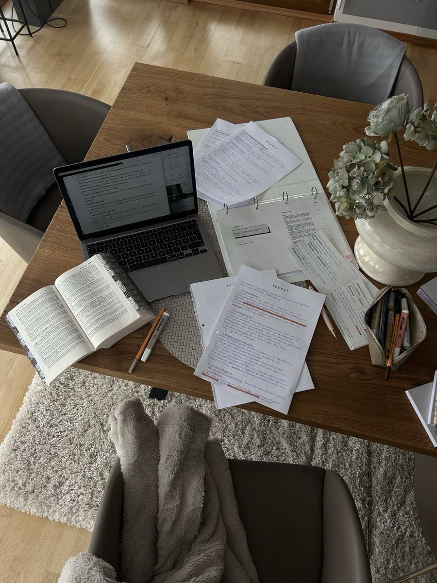 A desk with a laptop, notes and coffee